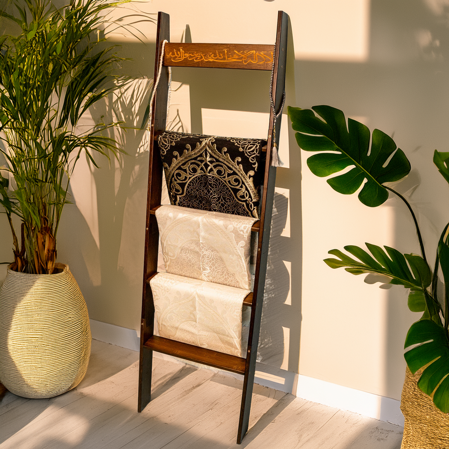 Light brown Shahadah ladder leaning against a wall to display prayer rugs and hijabs.